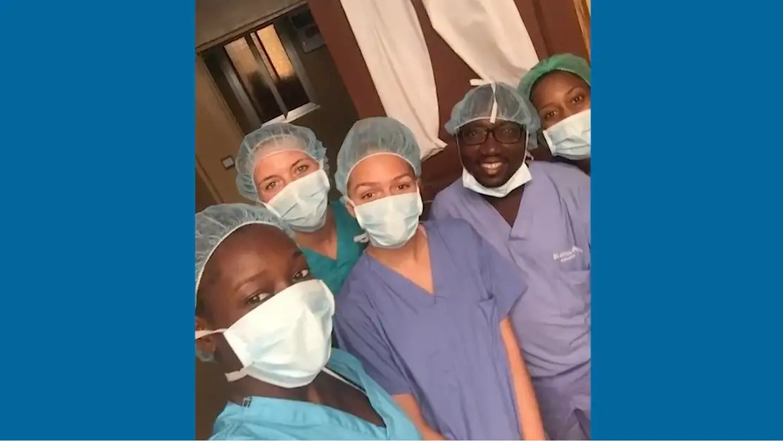 Group of doctors in scrubs and face masks look at camera